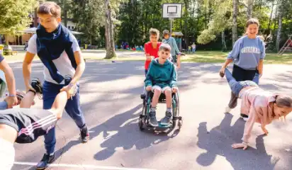 Kinder spielen gemeinsam auf dem Gelände des Ferienwaldheims.