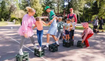 Betreuende und Kinder spielen gemeinsam auf dem Platz.