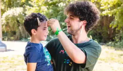 Betreuer und Kind geben sich ein High-Five.