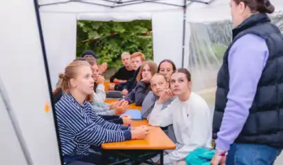 Jugendliche besprechen eine Aufgabe in einem Zelt.